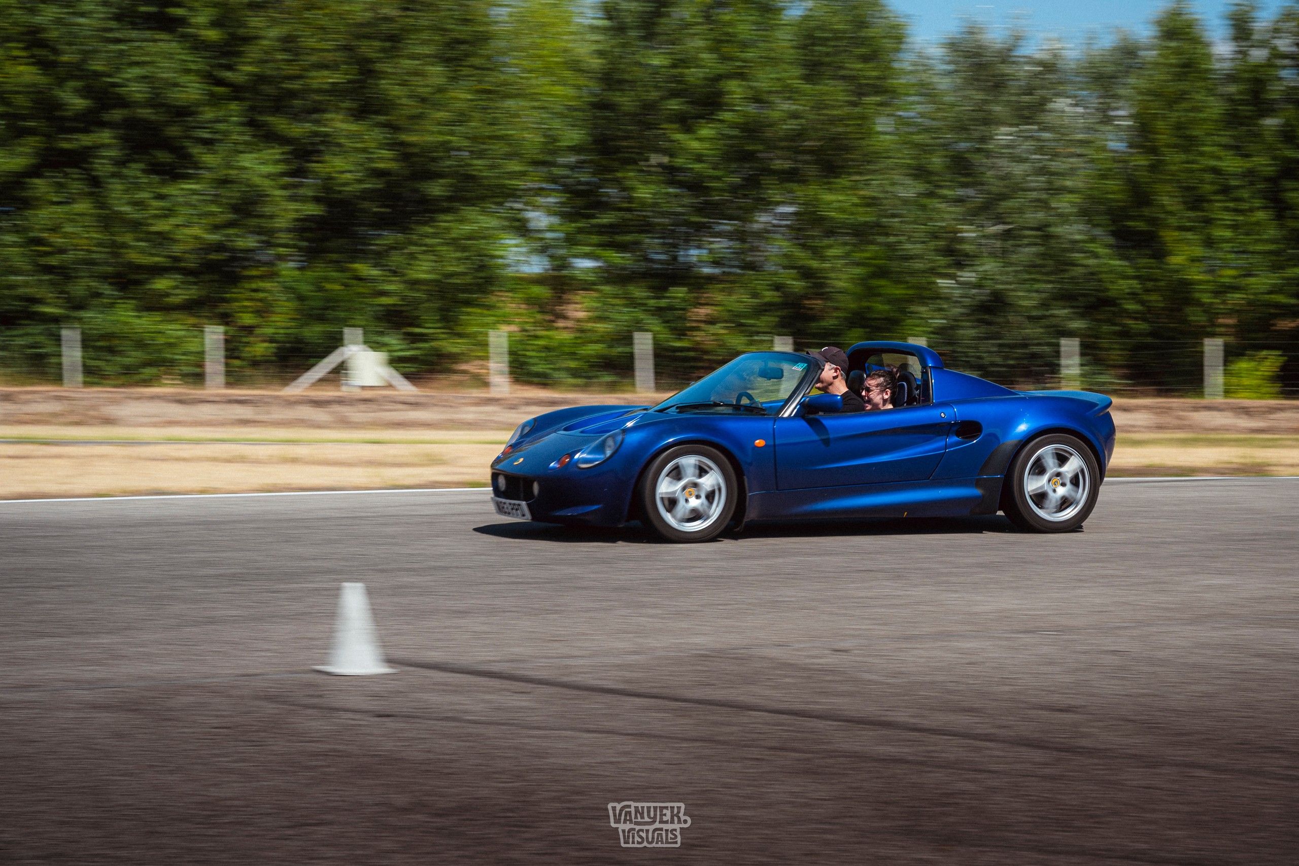 Blue Lotus Elise at speed on a race circuit