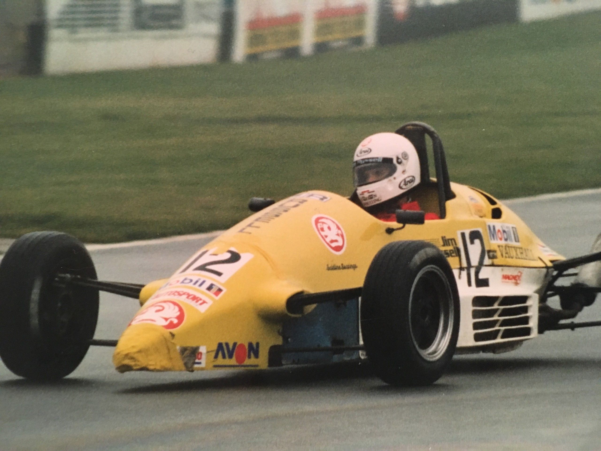 Yellow single-seater cornering on a race circuit