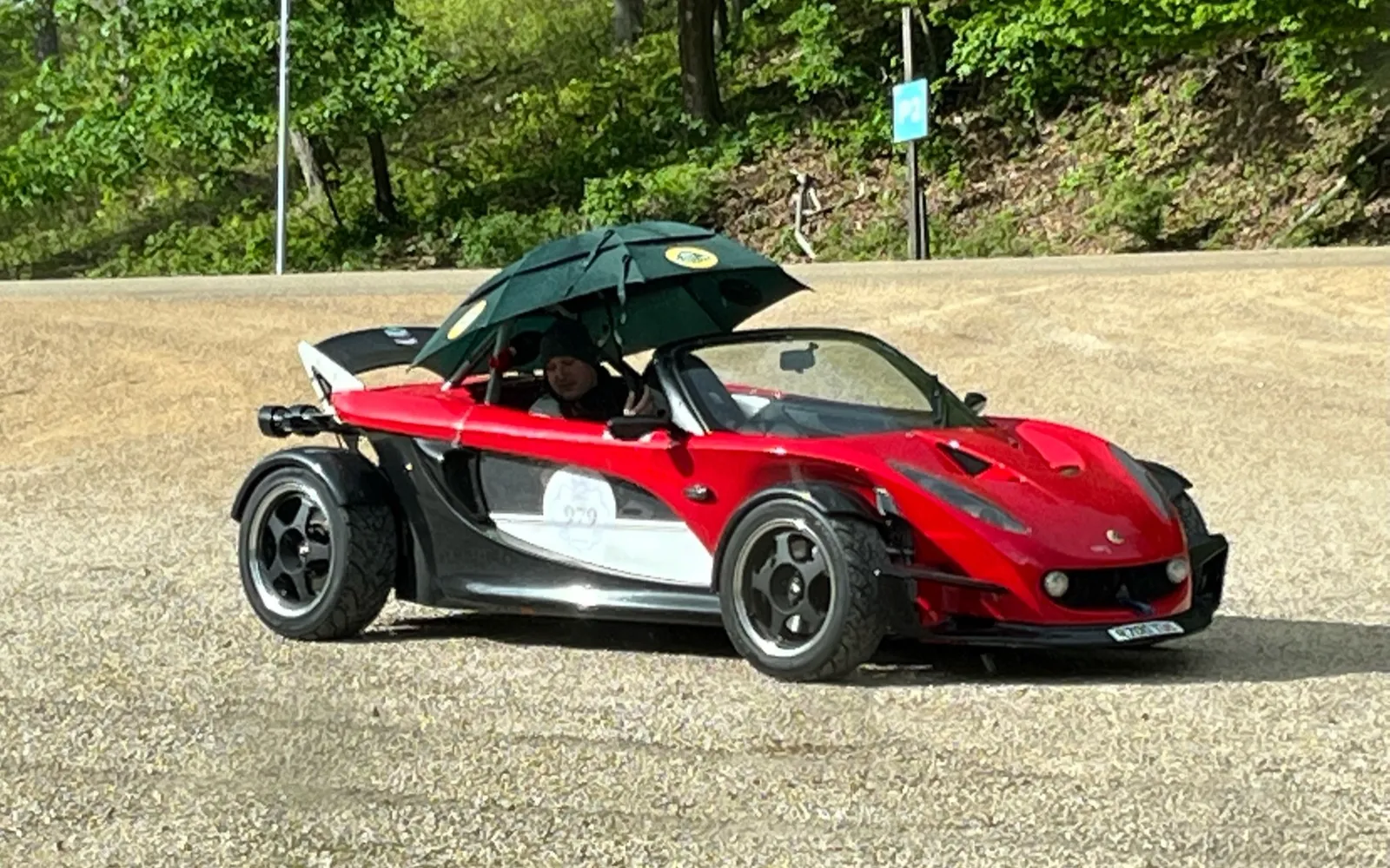Red Lotus 340R in the paddock under an umbrella