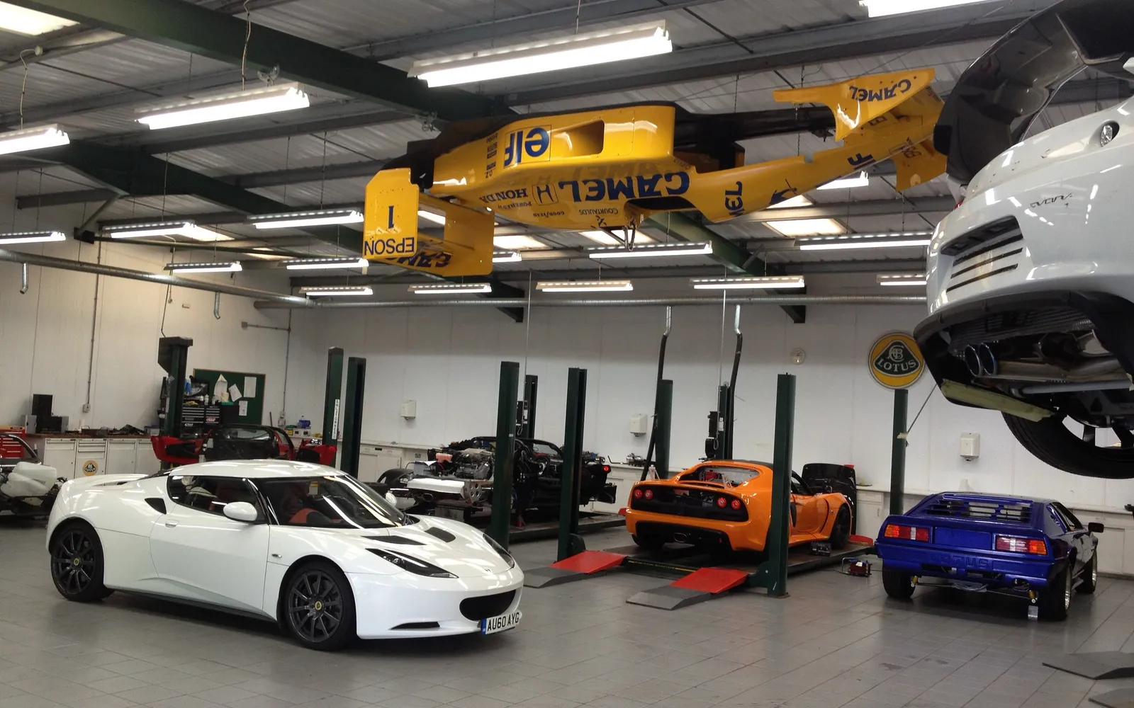 Lotus workshop with cars on the lifts and on the floor
